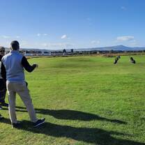 Players reviewing golf performance data during a swing analysis and coaching session.