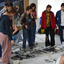 Group of young students looking at a drawing on the floor