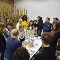 Group of young students gathered around a painting