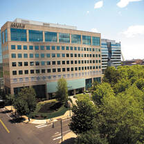 A large building with big windows and trees out front