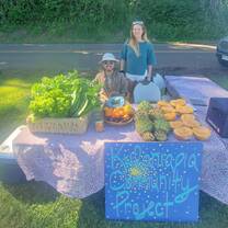 Smiling farmers at a farmers market stall