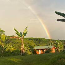 A rainbow over a cabin in the jungle
