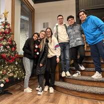 A group of students poses by a Christmas tree they helped to decorate