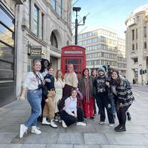 A group photo in front of a classic phone booth