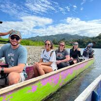 A group sits in a colorful canoe. 