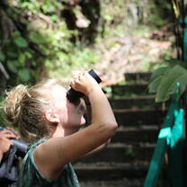 A girl looks through a set of binoculars. 