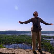 woman standing on bluff in front of river