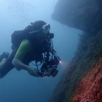 A diver poses with an undewater camera 
