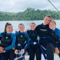 a group of divers smile on a boat