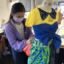 Student draping and pinning garment on mannequin