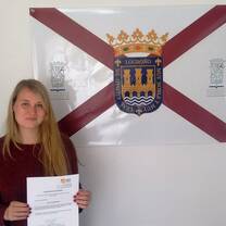 student smiling with her certificate