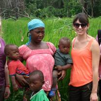 volunteer standing with a Liberian woman and her children