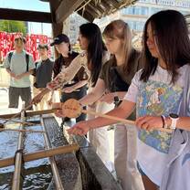 girls lifting water into wood spoons