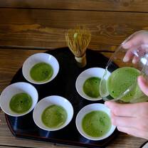 pouring green matcha into five cups