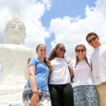 Group of students in front of a white Buddha 