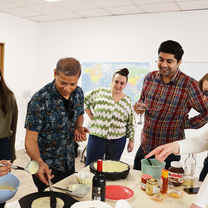 Students participating in a crêpe-making workshop as part of a French language immersion program in Paris.