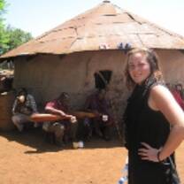Volunteer in front of a hut in Tanzania