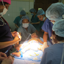 Assisting a group of doctors in a child surgery