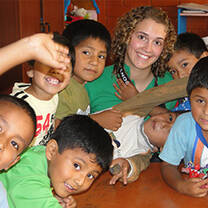 A high school volunteer with local children in Lima, Peru