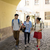 Three students walk on the street.