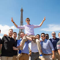 Students posing together at the Eiffel Tower in Paris, an iconic landmark originally built for the 1889 World’s Fair and now one of the most visited monuments in the world.