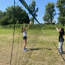 Two students playing volleyball on a sunny day