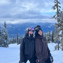 Two people on a snowy mountain with ski gear on