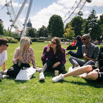 Students sitting on a lawn in London
