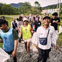 A group of people walking on a path with sacks for the clean-up action