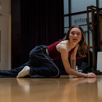 A girl in a studio on all fours wearing comfortable clothing