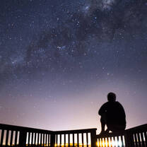 Student poses beneath star filled sky.