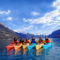 Group of students in kayaks on a lake in Switzerland.