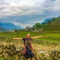 Student standing in front of rice fields