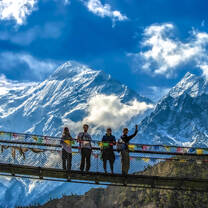 Students pose on bridge in Himalayas.