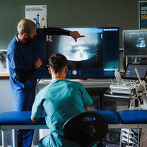 Doctor teaching ultrasound imaging to students during a hands-on clinical skills summer programme in Liverpool