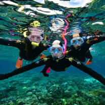 three scuba divers posing under water