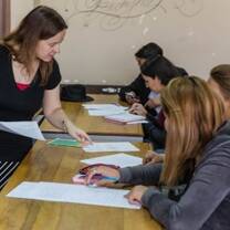 A teaching volunteer instructs students during an English lesson at a university
