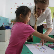 A teacher helping a young student