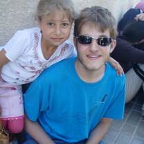 A VFP volunteer smiles with a child in Palestine
